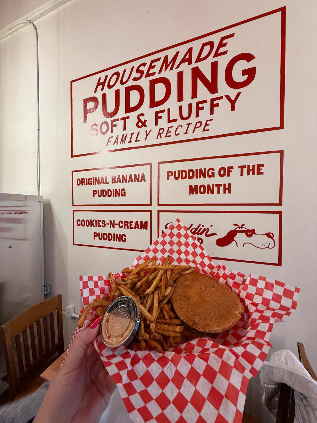 burger in front of sign located at Eat Baddies in Gainesville Georgia